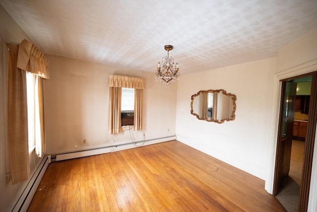 102 Margin St, Salem, MA 01970 - empty room featuring a baseboard heating unit, wood finished floors, a chandelier, and baseboards