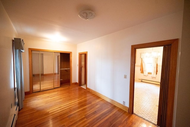 102 Margin St, Salem, MA 01970 - unfurnished bedroom featuring baseboard heating, wood finished floors, and baseboards