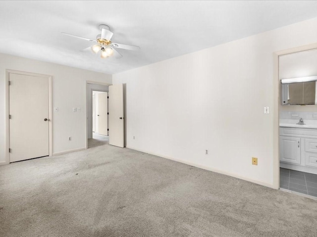 unfurnished bedroom featuring carpet flooring, a sink, baseboards, and ensuite bathroom