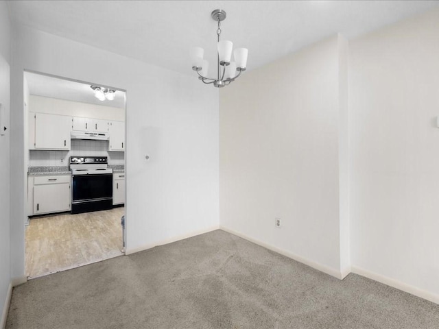 unfurnished dining area featuring light carpet, baseboards, and an inviting chandelier