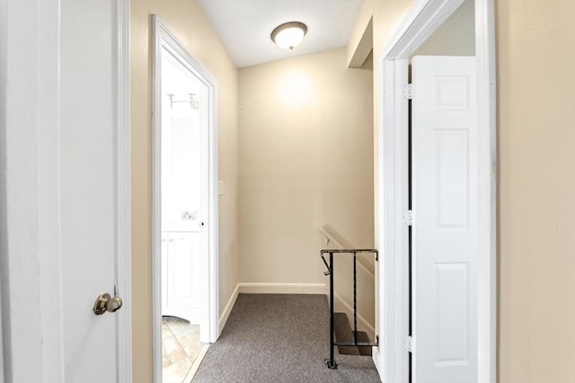 corridor with carpet, baseboards, and an upstairs landing