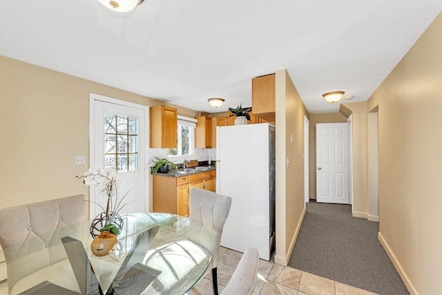 dining space with light carpet and baseboards