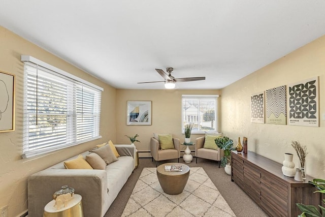 carpeted living room with ceiling fan, baseboard heating, and a textured wall