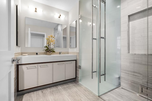 bathroom with vanity and a shower with door