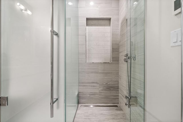 bathroom featuring a shower with shower door