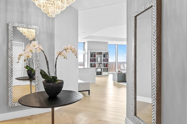 hallway featuring an inviting chandelier and a wall of windows