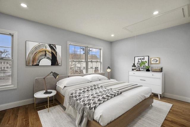 bedroom with multiple windows and dark wood-type flooring