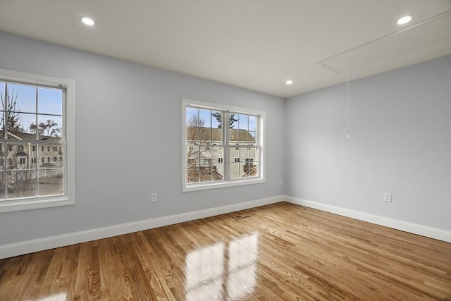 spare room with hardwood / wood-style flooring and a wealth of natural light