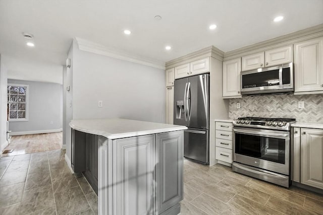 kitchen featuring appliances with stainless steel finishes, tasteful backsplash, a kitchen island, and ornamental molding