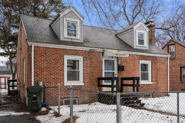 cape cod-style house with a fenced front yard and brick siding