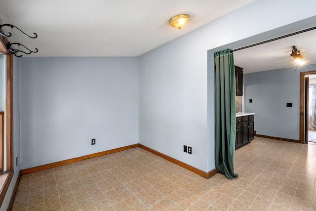 spare room with light floors and baseboards