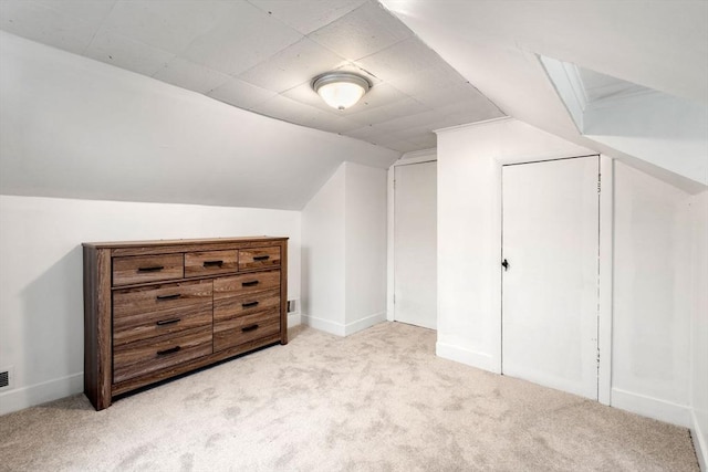 additional living space with lofted ceiling, light colored carpet, and baseboards