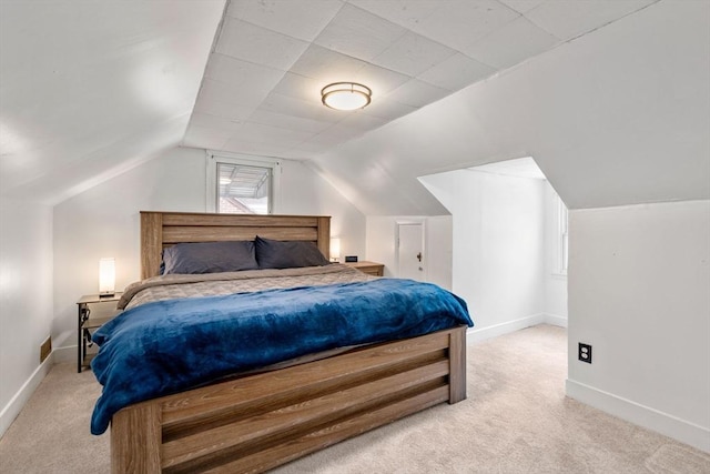 bedroom with light carpet, lofted ceiling, and baseboards