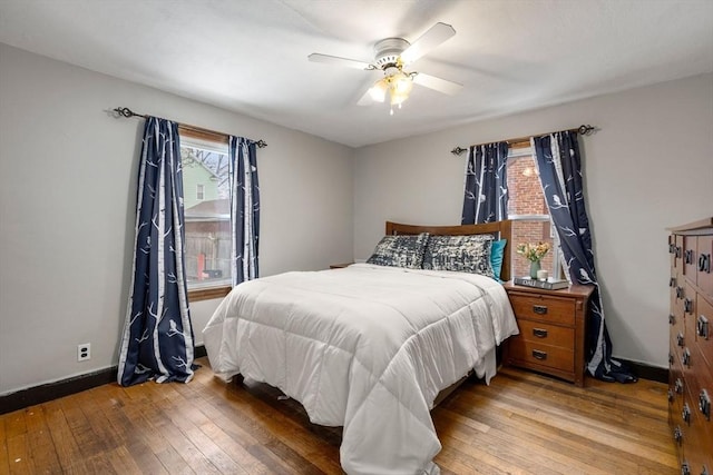 bedroom featuring wood-type flooring, baseboards, and a ceiling fan