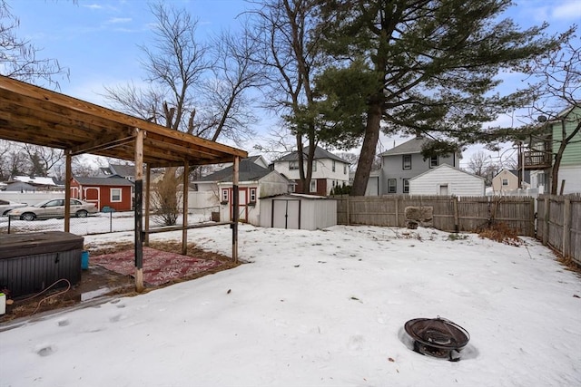 snowy yard with a residential view, an outdoor structure, and a shed