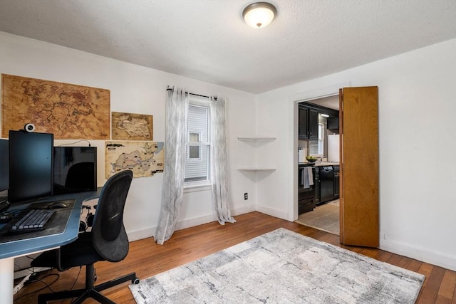 office space featuring wood-type flooring, a textured ceiling, and baseboards