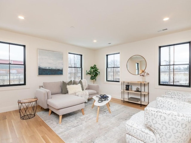 living area with visible vents, recessed lighting, light wood-type flooring, and baseboards