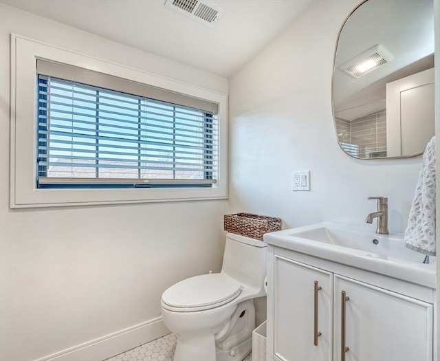 bathroom featuring vanity, toilet, baseboards, and visible vents