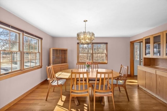 dining room featuring an inviting chandelier, light wood-style flooring, and baseboards