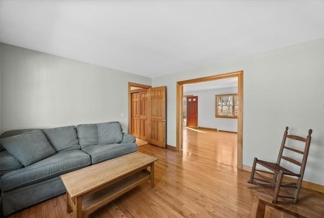 living area with light wood-type flooring and baseboards