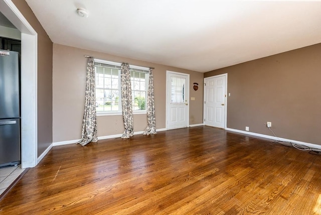 unfurnished living room featuring baseboards and wood finished floors