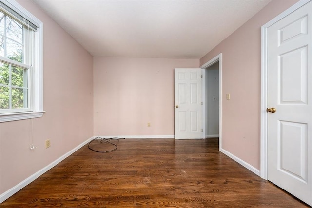 unfurnished bedroom featuring baseboards and dark wood finished floors