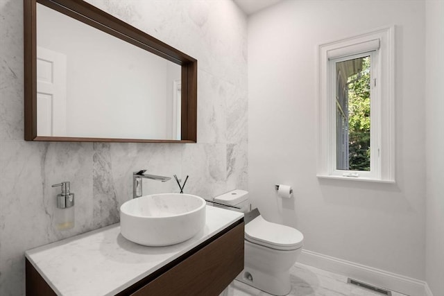 69 Princeton Rd, Brookline, MA 02467 - bathroom featuring decorative backsplash, vanity, and marble look tiles