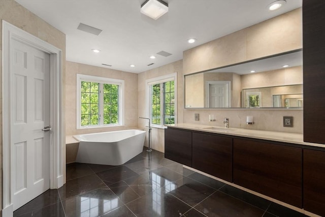 69 Princeton Rd, Brookline, MA 02467 - full bath with granite tiled floors, vanity, a freestanding bath, and recessed lighting