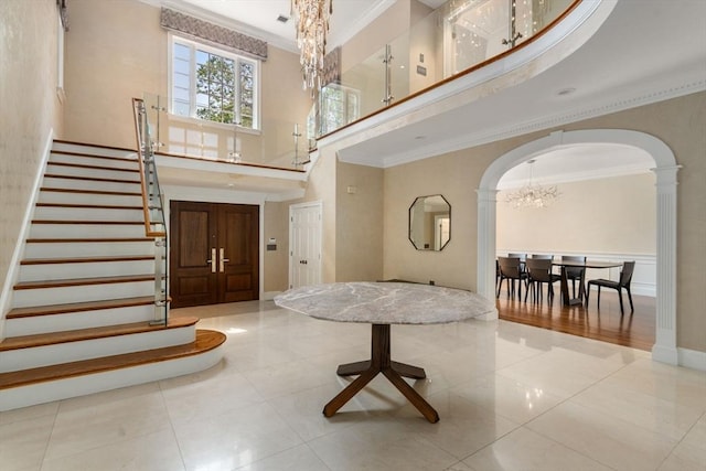 69 Princeton Rd, Brookline, MA 02467 - entryway featuring a towering ceiling, a chandelier, arched walkways, stairs, and crown molding