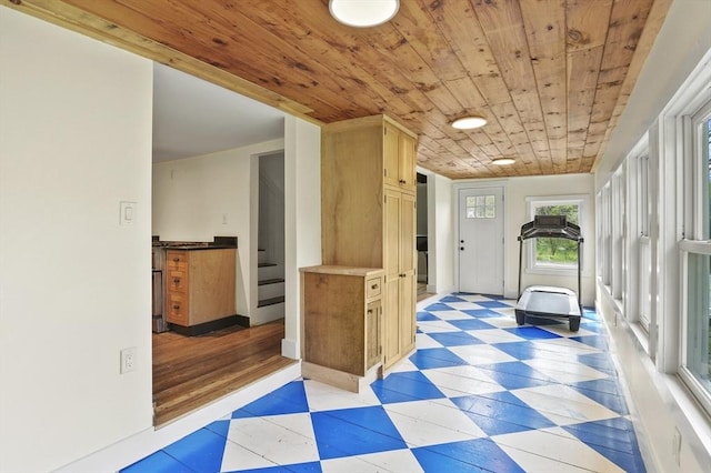 corridor with wood ceiling, light floors, stairway, and baseboards