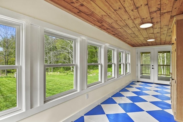 unfurnished sunroom featuring tile patterned floors, french doors, wooden ceiling, and healthy amount of natural light