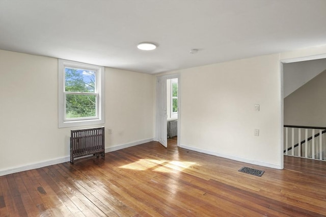 empty room with hardwood / wood-style floors and baseboards