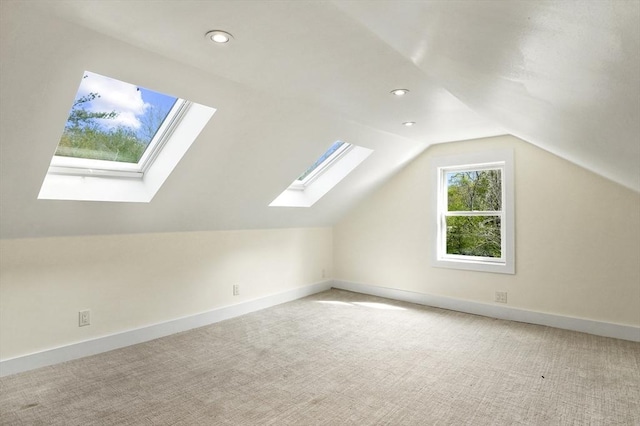 bonus room with a skylight, carpet, lofted ceiling, recessed lighting, and baseboards