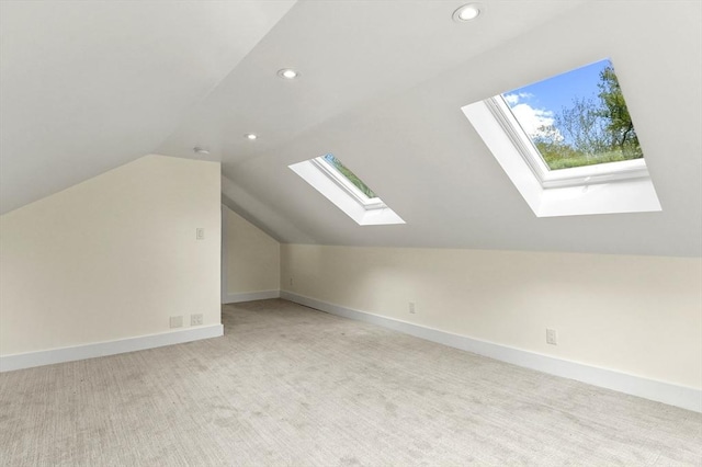 bonus room featuring a skylight, lofted ceiling, light carpet, recessed lighting, and baseboards