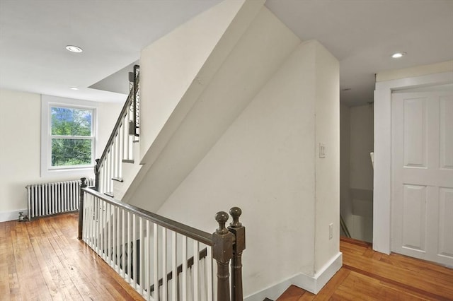 stairs featuring radiator heating unit, hardwood / wood-style floors, recessed lighting, and baseboards