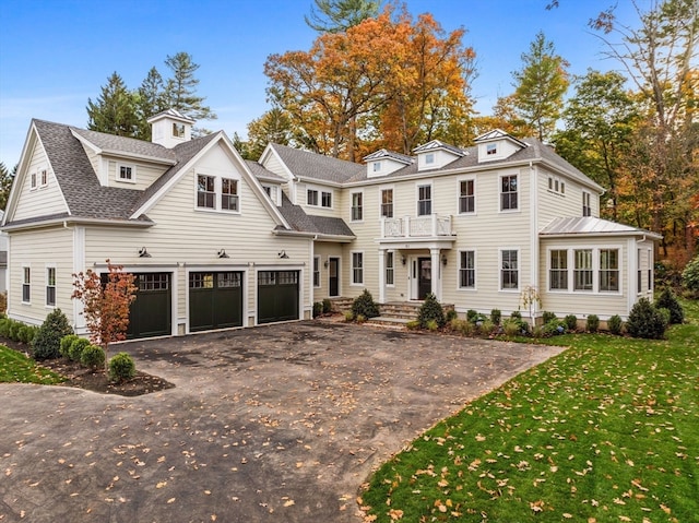 view of front of property featuring a front yard, a garage, and a balcony