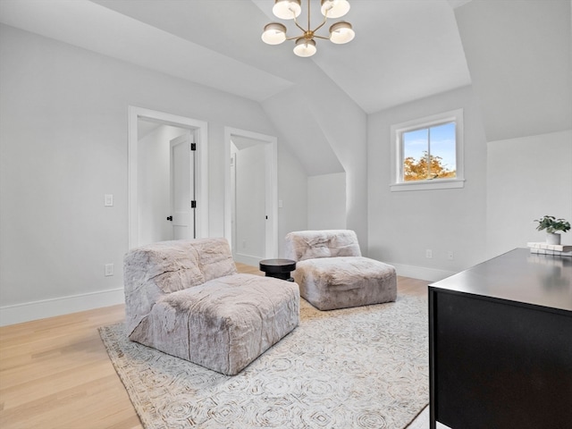 living area featuring an inviting chandelier, hardwood / wood-style floors, and vaulted ceiling