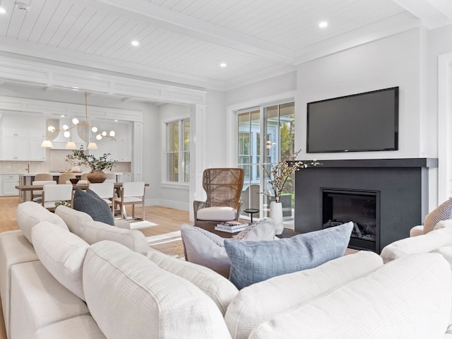 living room with wood ceiling, beam ceiling, light hardwood / wood-style flooring, crown molding, and a chandelier