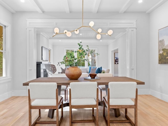 dining room with beamed ceiling, ornamental molding, light hardwood / wood-style flooring, and an inviting chandelier