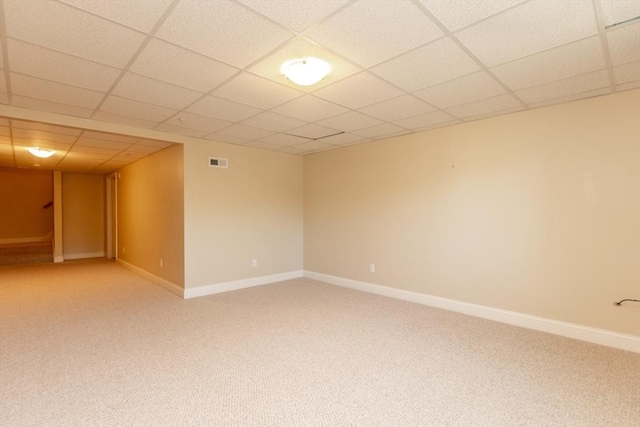 carpeted spare room with a drop ceiling