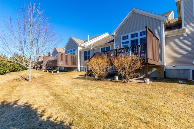 rear view of property featuring a yard and a deck