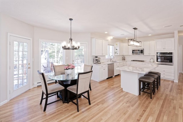 interior space featuring sink, stainless steel appliances, a center island, and white cabinets