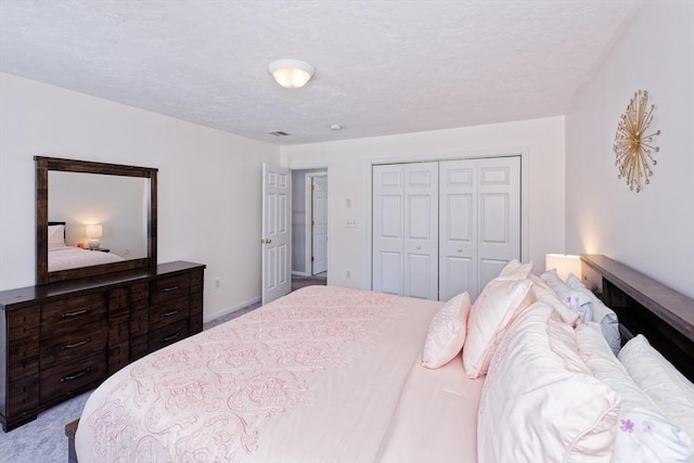 bedroom featuring light carpet, a closet, and a textured ceiling