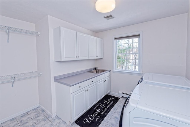 laundry room featuring sink, a baseboard heating unit, cabinets, light tile patterned flooring, and separate washer and dryer