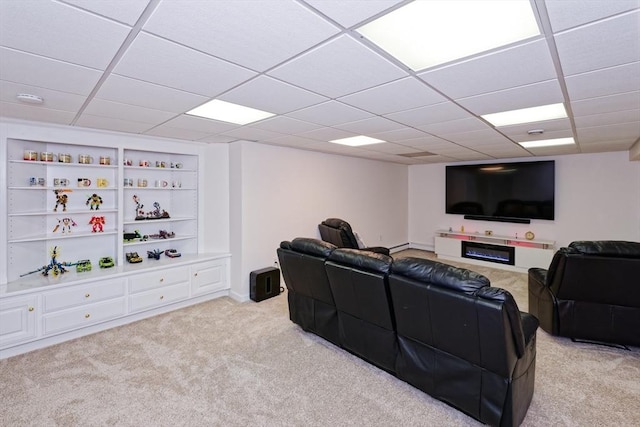 carpeted living room featuring a drop ceiling and built in features