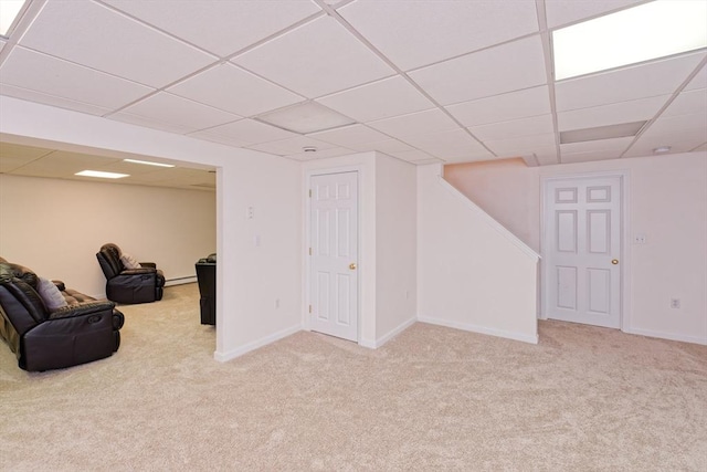 basement with light colored carpet and a drop ceiling