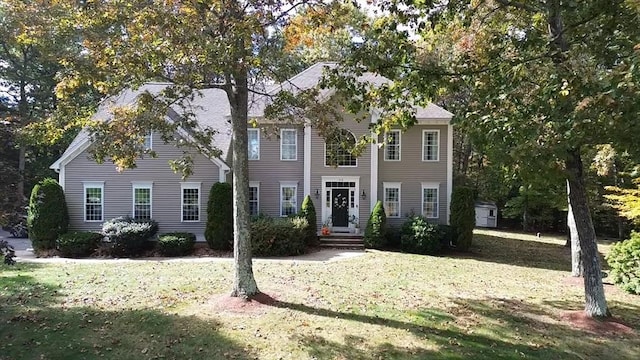 colonial-style house featuring a front lawn