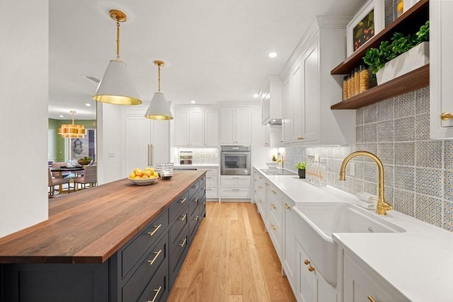 130 Mount Auburn St Unit 310, Cambridge, MA 02138 - kitchen with wood counters, stainless steel oven, white cabinetry, black electric stovetop, and recessed lighting