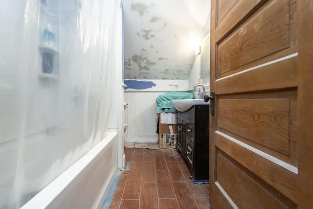 bathroom with vaulted ceiling, shower / bath combo with shower curtain, and vanity