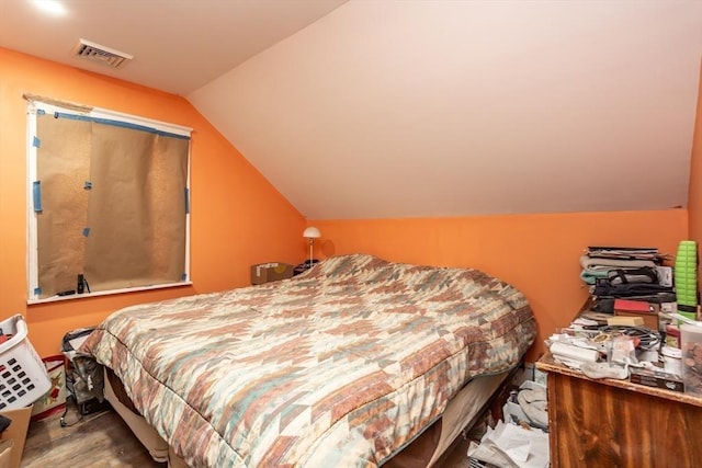 bedroom with vaulted ceiling and hardwood / wood-style floors